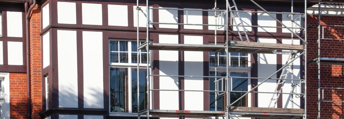 Ein Gerüst steht vor der Fassade eines Fachwerkhauses.